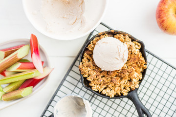 Homemade cooked rhubarb and apple crumble with oatmeal and vanilla ice cream