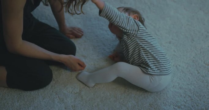 Mother playing with toddler son on rug