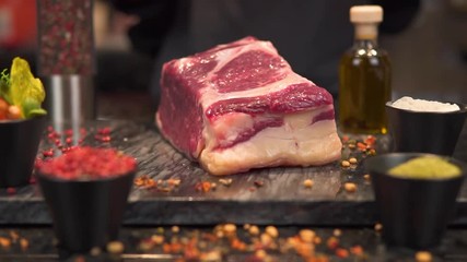 Close-up. A piece of meat falls on the board for cooking, Slow motion - Powered by Adobe