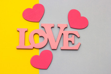 Wooden hearts on a multi-colored background, top view