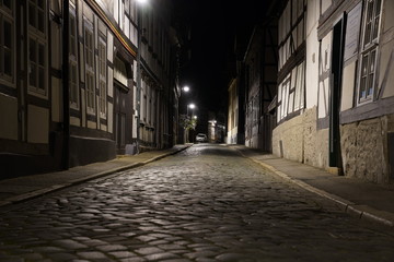  Tiny street with old nordic style houses at night in the town of Goslar, Germany in the Harz region.