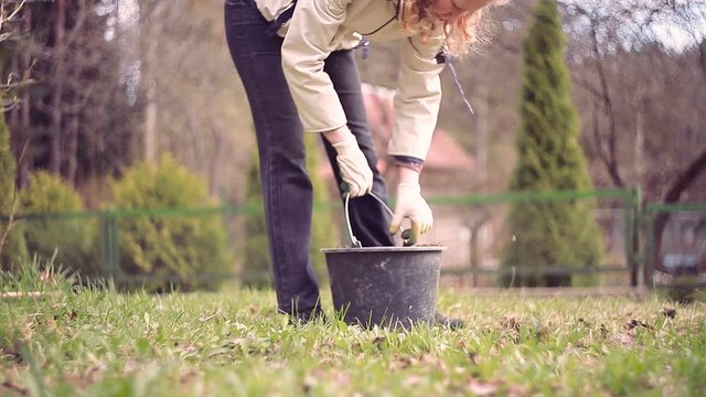 Woman digging soil and dirt in garden with shovel