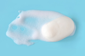 Soap foam bubbles on blue background macro close up.