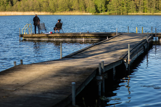Fish fishing at a lake in central europe. Anglers fishing on the pier.