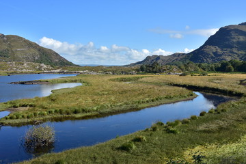 Fototapeta na wymiar Blue calm water of lake in valley in Reeks mountain range in Ireland.