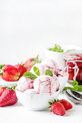 Strawberry ice cream with topping, decorated with mint leaves, white background, high key, selective focus