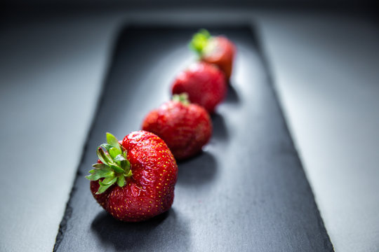 A macro shot and a colorful combination for two very good fruits: strawberries and pomegranates.