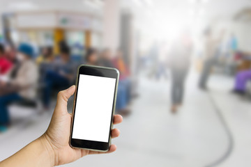 Hand hold on mobile with hospital service background