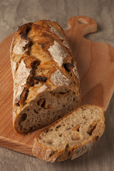 Wheat loaf with dried apricots on a wooden board