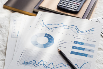 Obraz premium Graphs analysis documents work at home on bed.