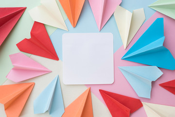 colourful paper airplane and blank white memo paper pad on colorful pastel background. memo,list,organize and air mail concept