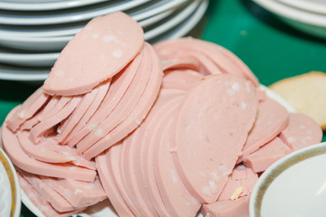 The sausage is chopped on a plate. Sausage cut. Slices of sausage on a plate.