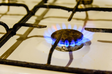 Gas burner on the white kitchen stove