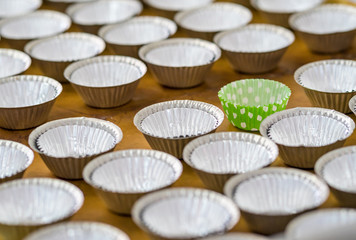 colourful paper cases for bake muffins on wooden tray