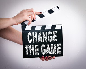 Change the game. Business concept. Female hands holding movie clapper