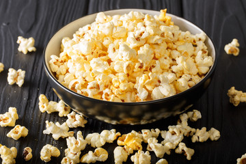 Cheddar cheese salted popcorn closeup in a  bowl on table. vertical
