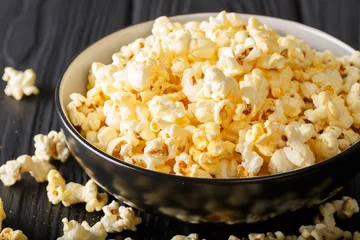  Popular snack: salted popcorn with cheddar cheese and parmesan in a bowl close-up. horizontal © FomaA