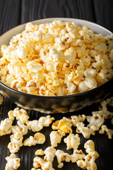 Delicious cheesy popcorn in a bowl close-up on a table. vertical