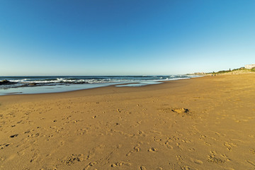 Patterned Beach Sand with Footprints Coastal Blue Sky Landscape