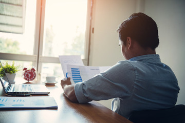Businessman analyzes market data on charts.