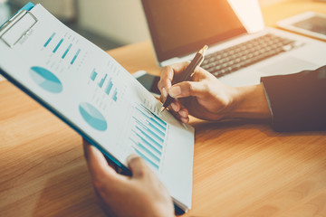 Businessmen sit and look at earnings data.