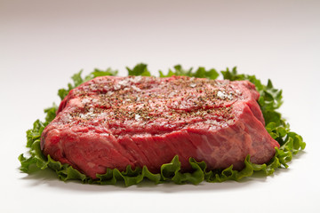 Raw Beef Roast On White Background with Lettuce