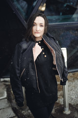 Street Portrait of a woman. fashionable brunette in black clothes on style, a walker  open air in...