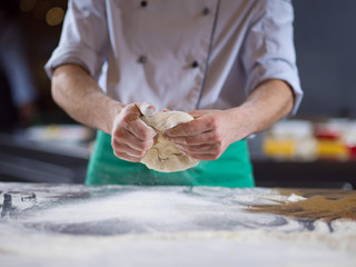 chef hands preparing dough for pizza