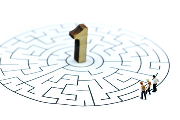 Miniature people : young businessman  with wooden number of 1 to be the first on maze,business competition concept.