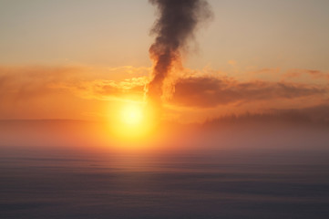 cold foggy winter evening by the river and smoke in the background