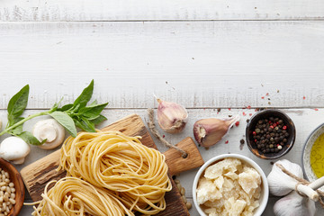 Raw homemade italian pasta and ingredients on white wooden background, cooking process