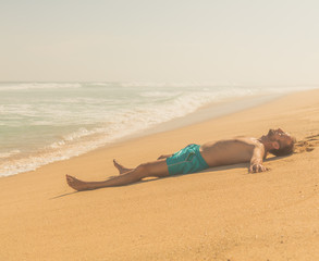 Man lying and enjoying on a sandy tropical beach.