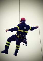 Obraz premium fireman hanging from a cord suspended with vintage effect