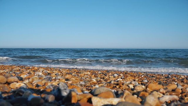 Pebble beach and waves of the sea.