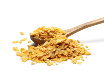 Crunchy corn flakes, cereal, muesli pile in wooden spoon  isolated on white background