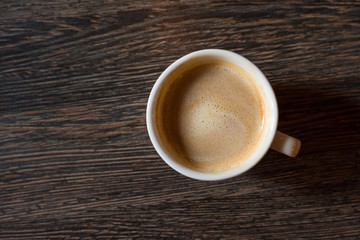 Cup of coffee on a wooden background. top view