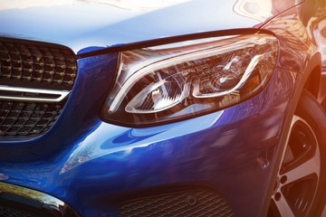 Beautiful headlight of blue car by close-up in a sunny day. Kind with to the side.