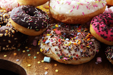 assorted donuts with chocolate frosted, pink glazed and sprinkles donuts.