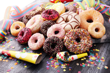 assorted donuts with chocolate frosted, pink glazed and sprinkles donuts.