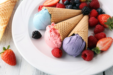 Set of ice cream scoops of different colors and flavours with blueberries, raspberries and blackberries.