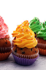 Tasty cupcakes on wooden background. Birthday cupcake in rainbow colors