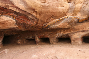 One of many amazing rainbow-coloured hollows of tombs and caves in ancient city of Petra, Jordan