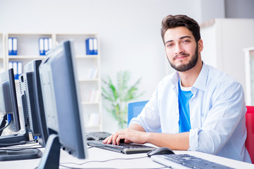 Obraz premium Businessman sitting in front of many screens