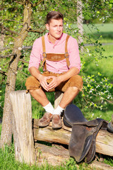 bavarian man sitting outdoors in nature