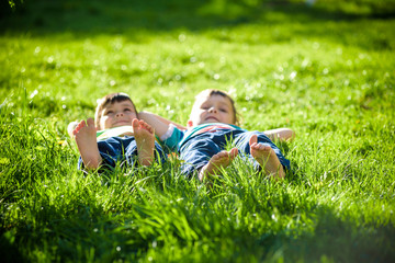 Children laying on grass. Family picnic in spring park - Powered by Adobe