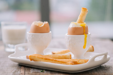 delicious breakfast with soft boiled eggs and crispy toasts, closeup