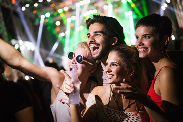 Happy friends having fun at music festival