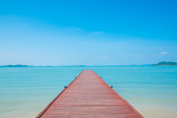 Wooden bridge leading to tropical in to the sea.