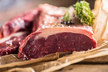 Raw rib eye beef steak with salt spices and herbs