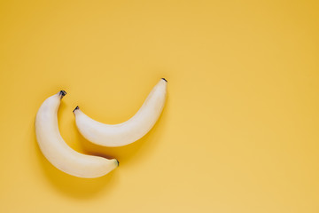 Fototapeta na wymiar Two ripe sweet testy bananas on yellow background top view with copy space
